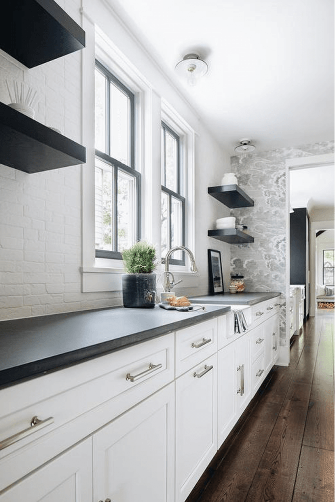 modern white brick kitchen backsplash with black countertops